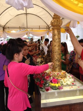 Pouring water and scented oils over Buddha statues and holy carvings